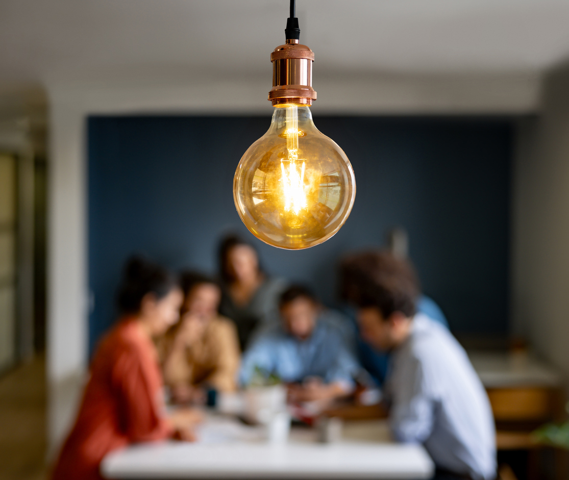 Creative team discussing a business idea in a meeting - focus on light bulb
